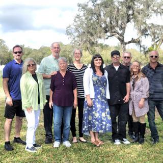 A cheerful gathering of friends and family enjoying a sunny day outdoors.