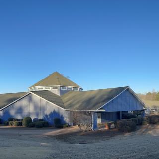 A church building with a gabled roof under a clear blue sky.
