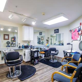 A modern hair salon with styling chairs and large mirrors.