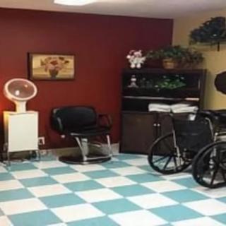 A cozy hair salon corner with chairs, a dryer, and a wheelchair on a checkered floor.