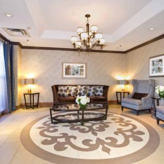 Elegant living room with a central sofa, armchairs, and chandelier lighting.