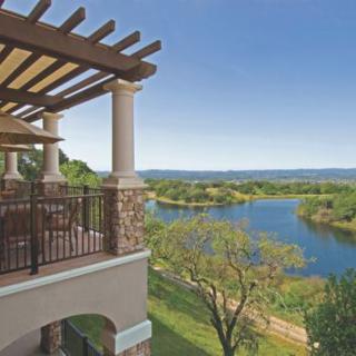 A beautiful balcony overlooking a serene lake and lush greenery.
