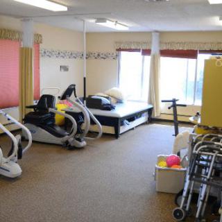 A rehabilitation room equipped with exercise machines and therapy tools.