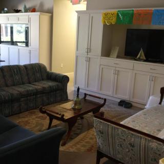 Cozy living room with sofas, a coffee table, and a television in a white cabinet.