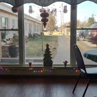 A cozy indoor scene showcasing holiday decorations with a view of the outside.