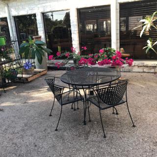 A cozy outdoor seating arrangement surrounded by vibrant flowers.