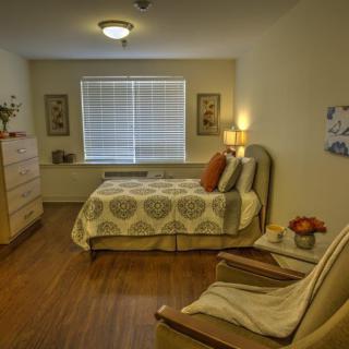 A cozy bedroom interior with warm lighting, a comfortable bed, and tasteful decor.