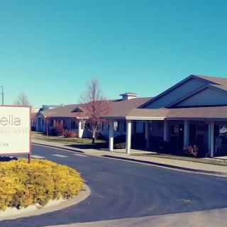 A sunny day view of a single-story building with a prominent entrance and landscaped surroundings.