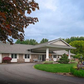 A residential building with a driveway and landscaped surroundings.