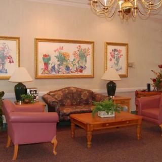 A cozy living room with comfortable seating, decorative lamps, and colorful wall art.