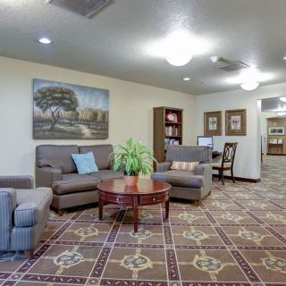 A cozy living room with comfortable seating, a central coffee table, and bookshelves.