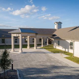 A modern building with a large entrance and columns under a clear blue sky.