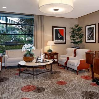 A cozy and elegant lobby with comfortable seating, decorative plants, and artwork.