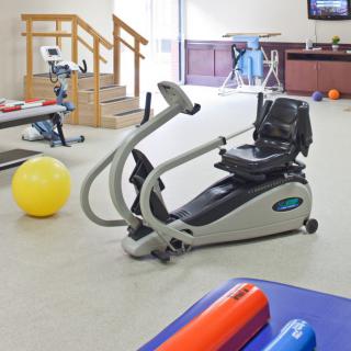 A physical therapy room featuring various exercise machines and fitness equipment.