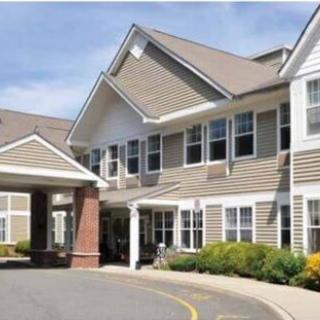 A two-story residential building with a covered entrance and well-maintained landscaping.