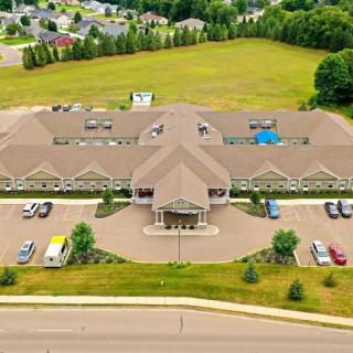Aerial view of a large building with surrounding parking lot and greenery.