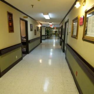 A well-lit hallway in a hospital with doors on either side.