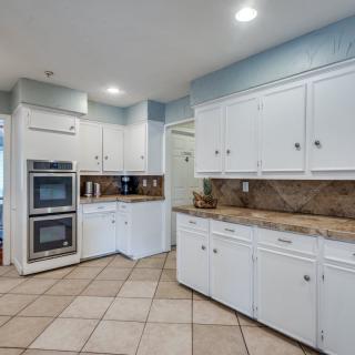 Spacious kitchen with white cabinets and modern appliances.
