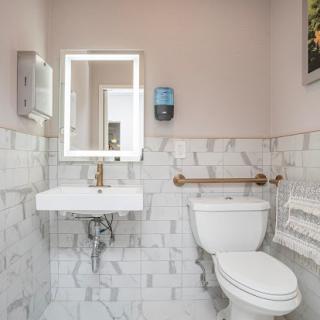 A modern bathroom featuring a toilet, sink, and stylish marble tiles.