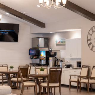 A modern dining area featuring stylish furniture and a cozy coffee station.