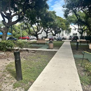 A serene park pathway lined with trees, inviting visitors to explore.