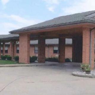 A brick building with a covered entrance and driveway.