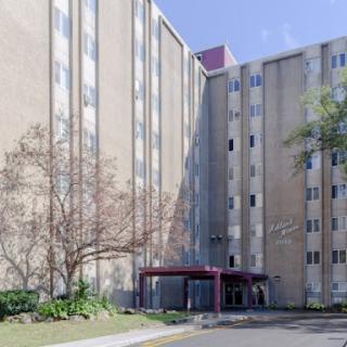 A modern multistory building featuring a welcoming entrance and landscaped surroundings.