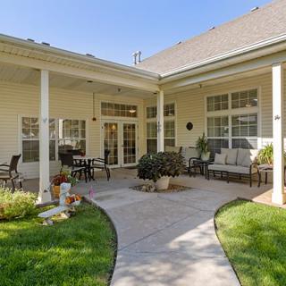 A cozy and inviting residential patio area with comfortable outdoor seating and a well-maintained garden.