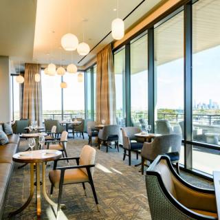 A modern restaurant interior with ample natural light and stylish seating.