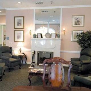 A cozy living room with traditional decor, featuring a fireplace and comfortable seating.