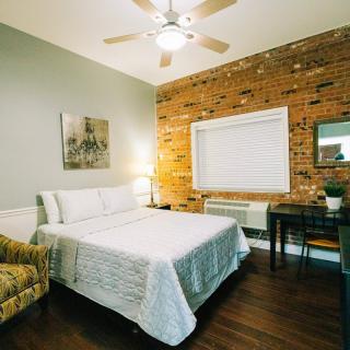 A cozy modern bedroom featuring a brick accent wall and stylish furnishings.