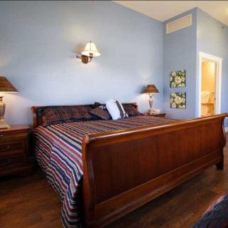 A cozy bedroom with a wooden bed frame and elegant lighting.