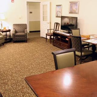 A cozy living room with seating area, television, and dining table.