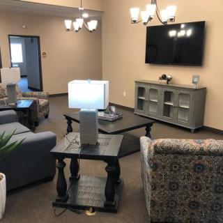 A cozy living room with comfortable seating, a television, and decorative lighting.