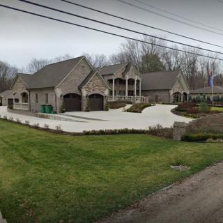 A luxurious suburban home with a spacious driveway and landscaped yard.