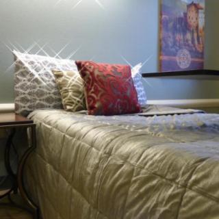 A neatly made bed with decorative pillows and a quilt in a cozy bedroom setting.