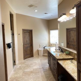 Spacious bathroom with a large mirror and elegant tile flooring.