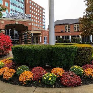 A beautifully landscaped hotel entrance adorned with vibrant autumn flowers.