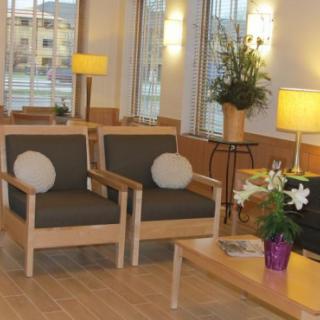 A comfortable waiting area with chairs, a table, and warm lighting.