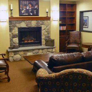 A cozy living room with a stone fireplace, comfortable seating, and wooden furniture.