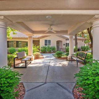 Covered entryway with benches and landscaped garden.