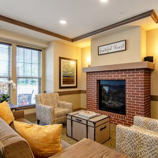 A cozy living room featuring a brick fireplace, comfortable seating, and tasteful decor.