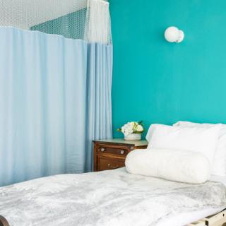 A hospital room with a bed, side table, and curtain.