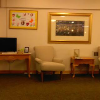 A cozy living room setup featuring comfortable chairs, a television, and decorative artwork on the walls.