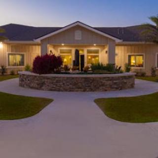 A beautifully lit house during the evening with well-maintained landscaping.