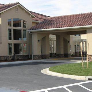 A modern building with a tiled roof and large windows at the entrance.