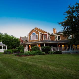 A picturesque suburban house with a large lawn and gazebo.