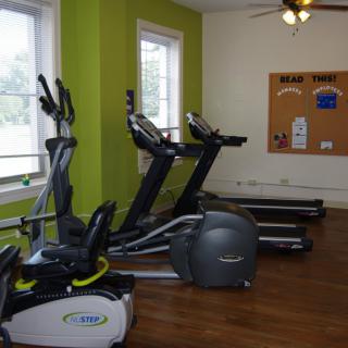 A gym room with treadmills and an elliptical machine.