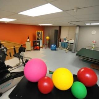 A therapy room with colorful exercise balls and rehabilitation equipment.