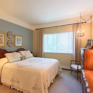 A cozy bedroom with elegant decor and a large bed near a window.